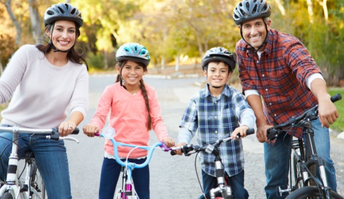 Family on bikes wearing helmets